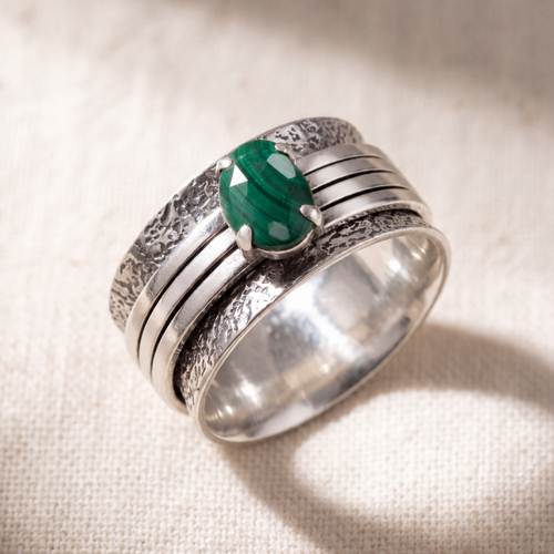 Brave Malachite sterling silver spinner ring on a bone linen ground