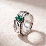 Close view of three bands and a faceted malachite stone turning on the Brave Malachite ring