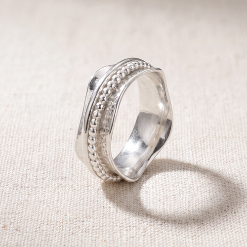Resilience sterling silver spinner ring on a bone linen ground