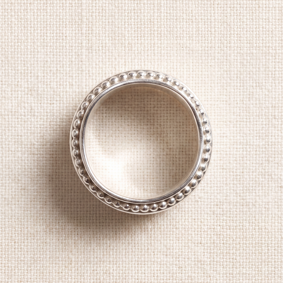 A woman's hand wearing the Resilience sterling silver spinner ring