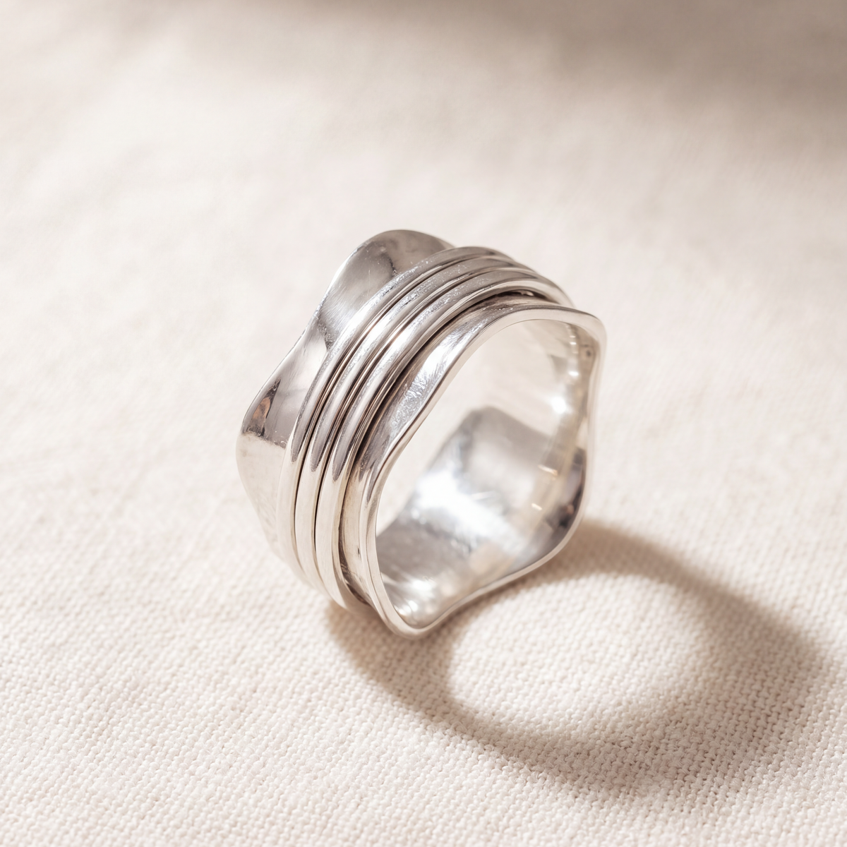 Strength sterling silver spinner ring on a bone linen ground