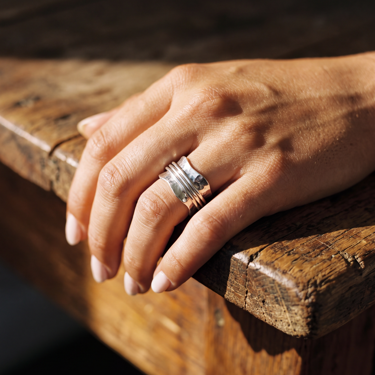 The Strength sterling silver spinner ring worn on the hand