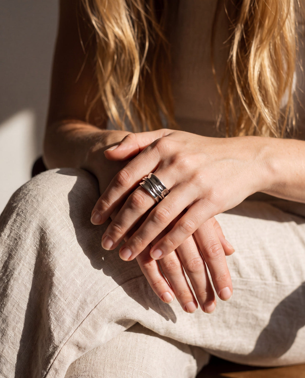 Worn, hands resting in the lap