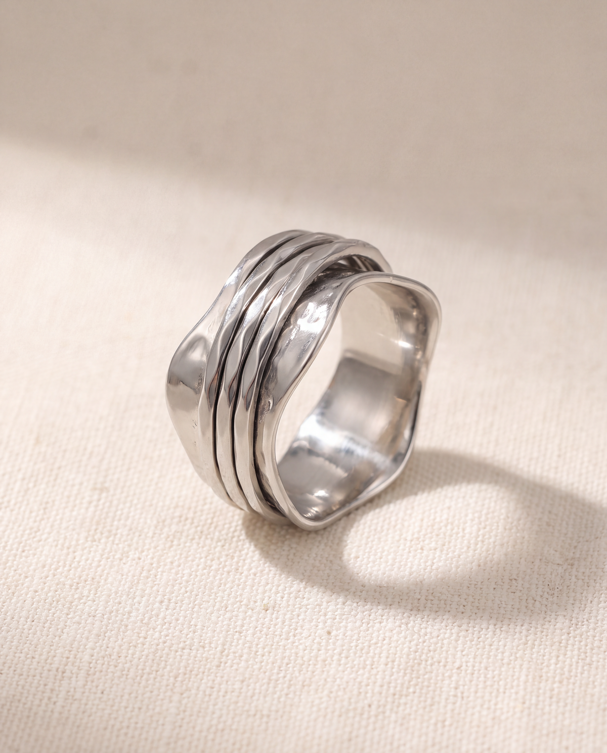 Wave 316L stainless steel spinner ring on a bone linen ground