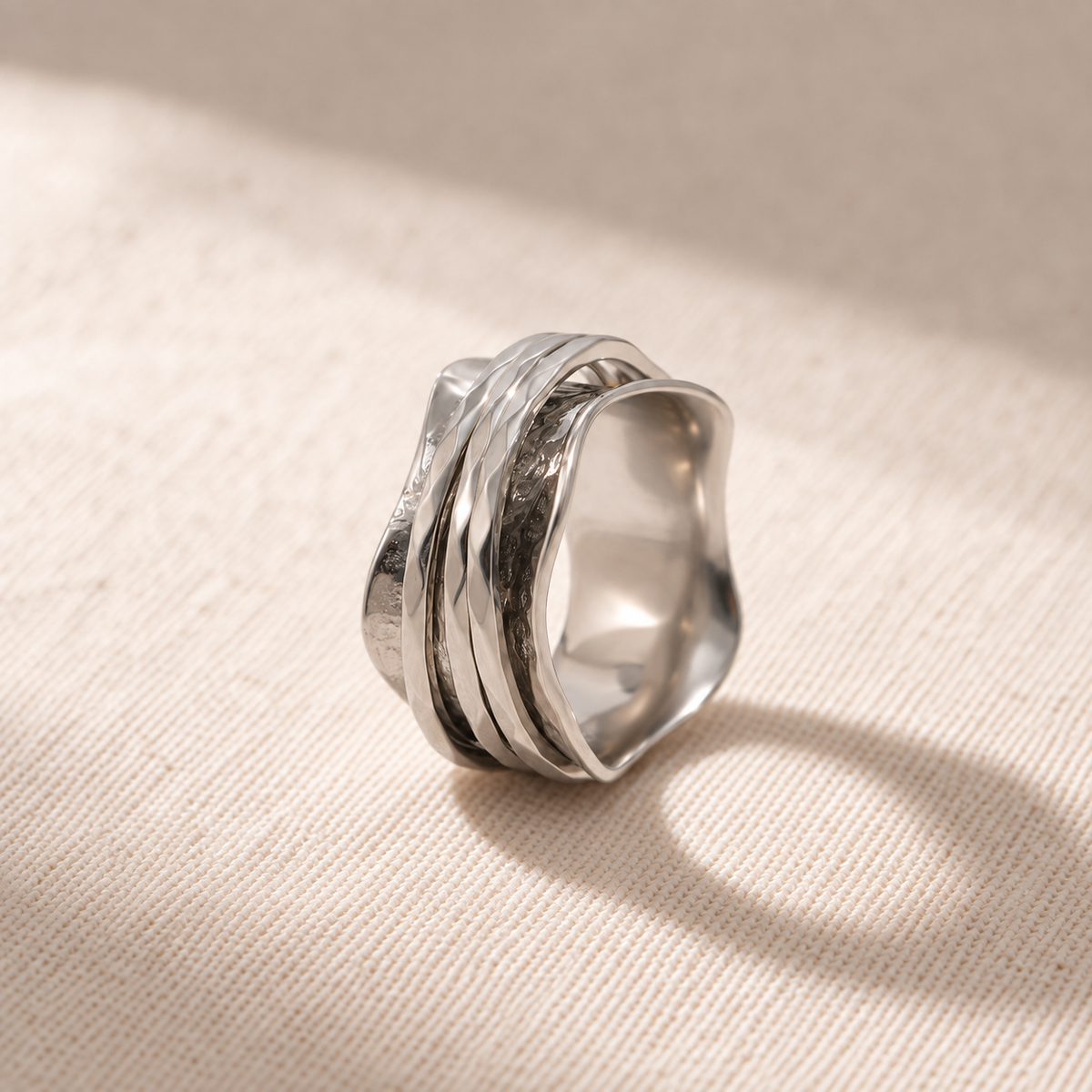 The Wave ring resting on natural linen
